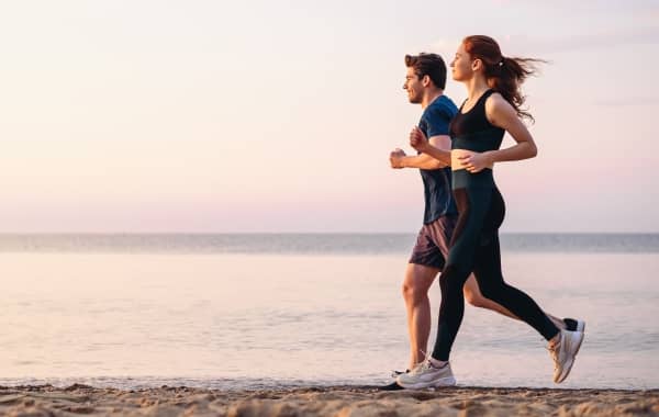 Couple jogging by the beach.