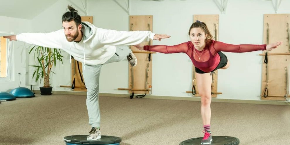 Couple balancing on Bosu balls.